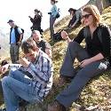 Students look at plants on mountaintop and rest from hiking.